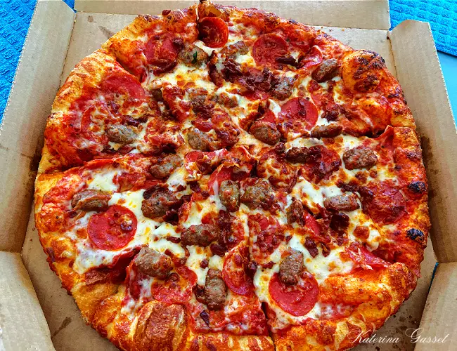 Photo of a large pizza in a box served at Marco's Pizza in Provo Utah. Overloaded with cheese and meat toppings, it is definitely a must-try for pizza lovers! Image captured by Katerina Gasset of the Gasset Group Real Estate Team, owner and author of the Move to Provo Utah website…