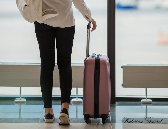 Photo of a young woman in the airport holding a luggage. Image created by Katerina Gasset, of The Gasset Group at EXP Realty and the owner of Get It Done for Me Virtual Services and Coach Katerina LLC
