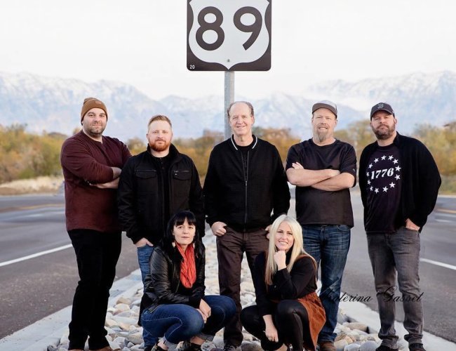 Live performance by Route 89 band in Orem, Utah, featuring musicians on stage with instruments, vibrant lighting, and an engaged audience.