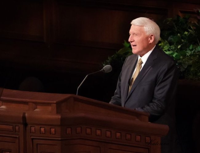 Devotional by Brother Jan E. Newman at Brigham Young University in Provo, Utah, featuring him speaking to an attentive audience in a peaceful setting.