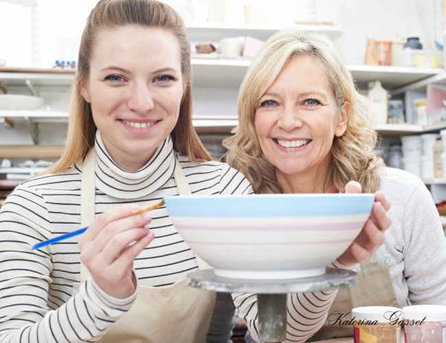 Ceramics class in Orem, Utah, showing participants shaping and decorating clay pots on pottery wheels in a creative and hands-on workshop environment.