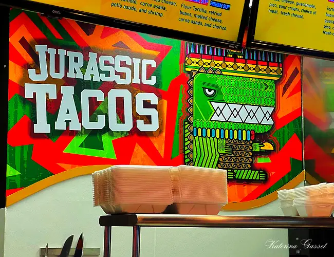Photo showing the logo of Jurassic Street Tacos in Orem Utah. The restaurant is colorfully designed with a dinosaur theme…