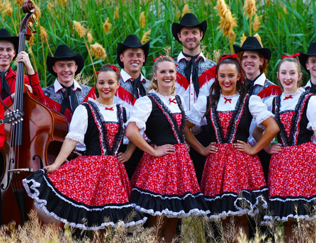 American Folk Ensemble performing traditional music and dance in Orem, Utah, showcasing vibrant costumes and lively folk tunes, captivating a diverse audience